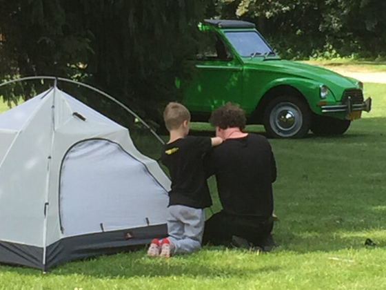 Een vader is met zijn zoon de tent aan het opzetten