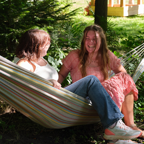 2 gasten zitten tijdens hun vakantie in een hangmat